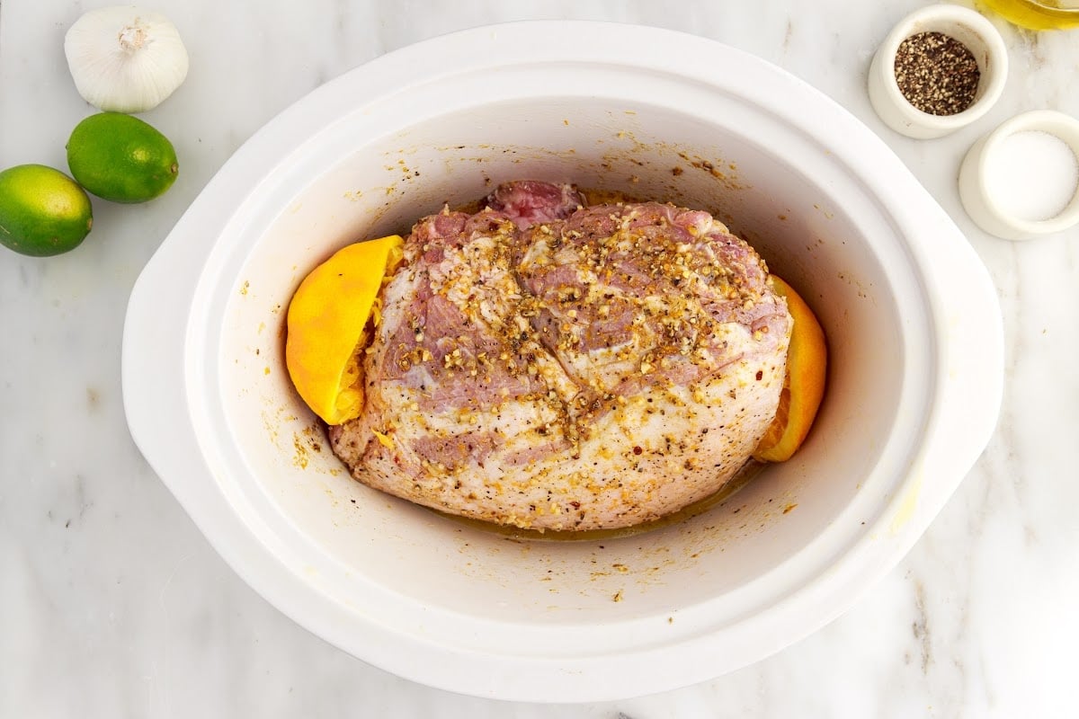 Oranges and Lime juice squeezed over the pork and placed into the crock pot next to the meat.