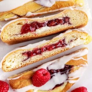 Raspberry cream cheese danish braid cut into several pieces to show the insides.