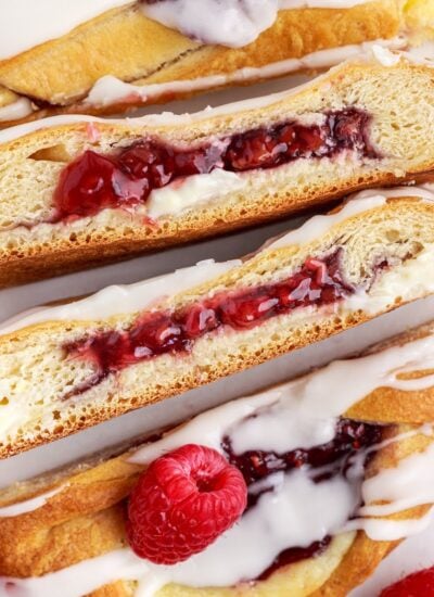 Raspberry cream cheese danish braid cut into several pieces to show the insides.