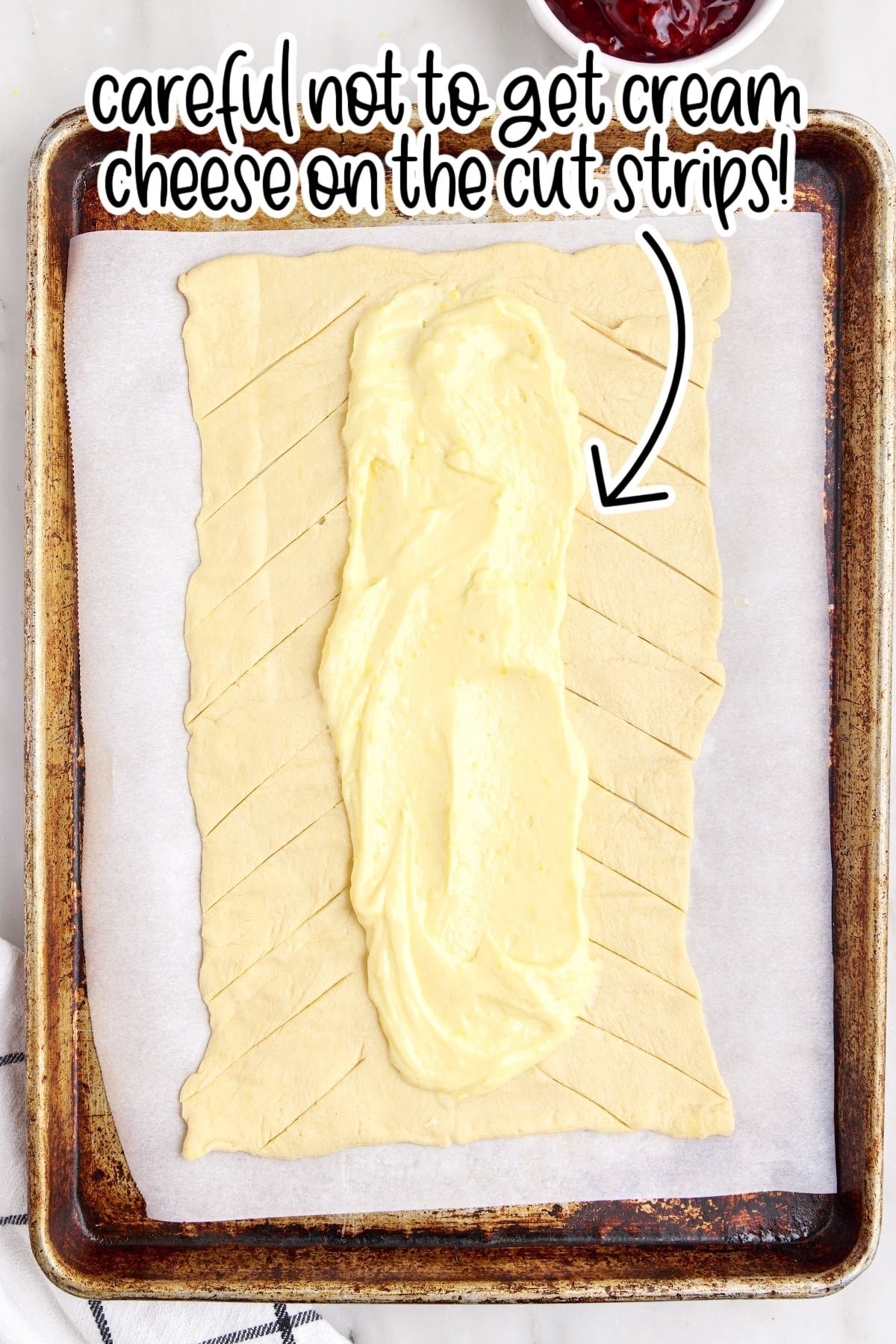 Cream cheese mixture being spread over the crescent roll dough.