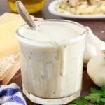 Jar filled with Alfredo Sauce.
