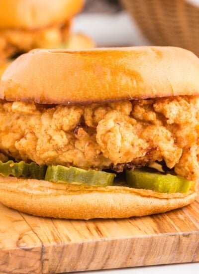 A homemade fried chicken sandwich with sauce and pickles.