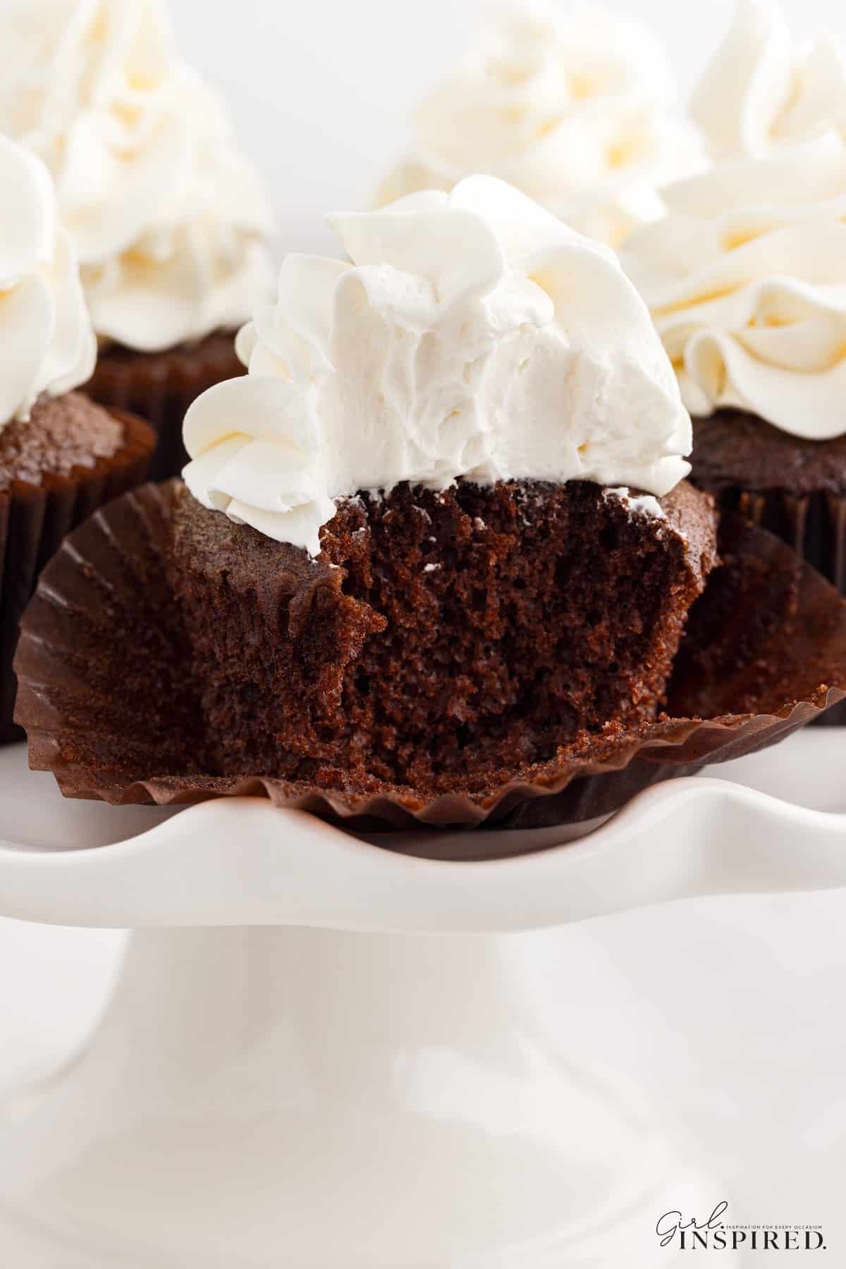 A bite taken from a cupcake topped with Marshmallow Cream Frosting.