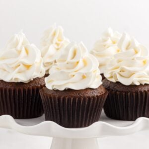 Close up of a cake platter full of cupcakes topped with Marshmallow Cream Frosting.