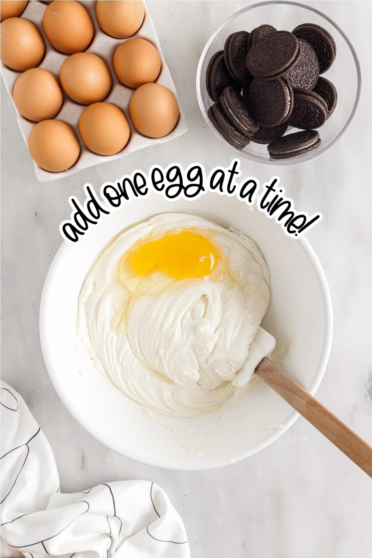 Adding one egg at a time to the cheesecake mixture, with text overlay.