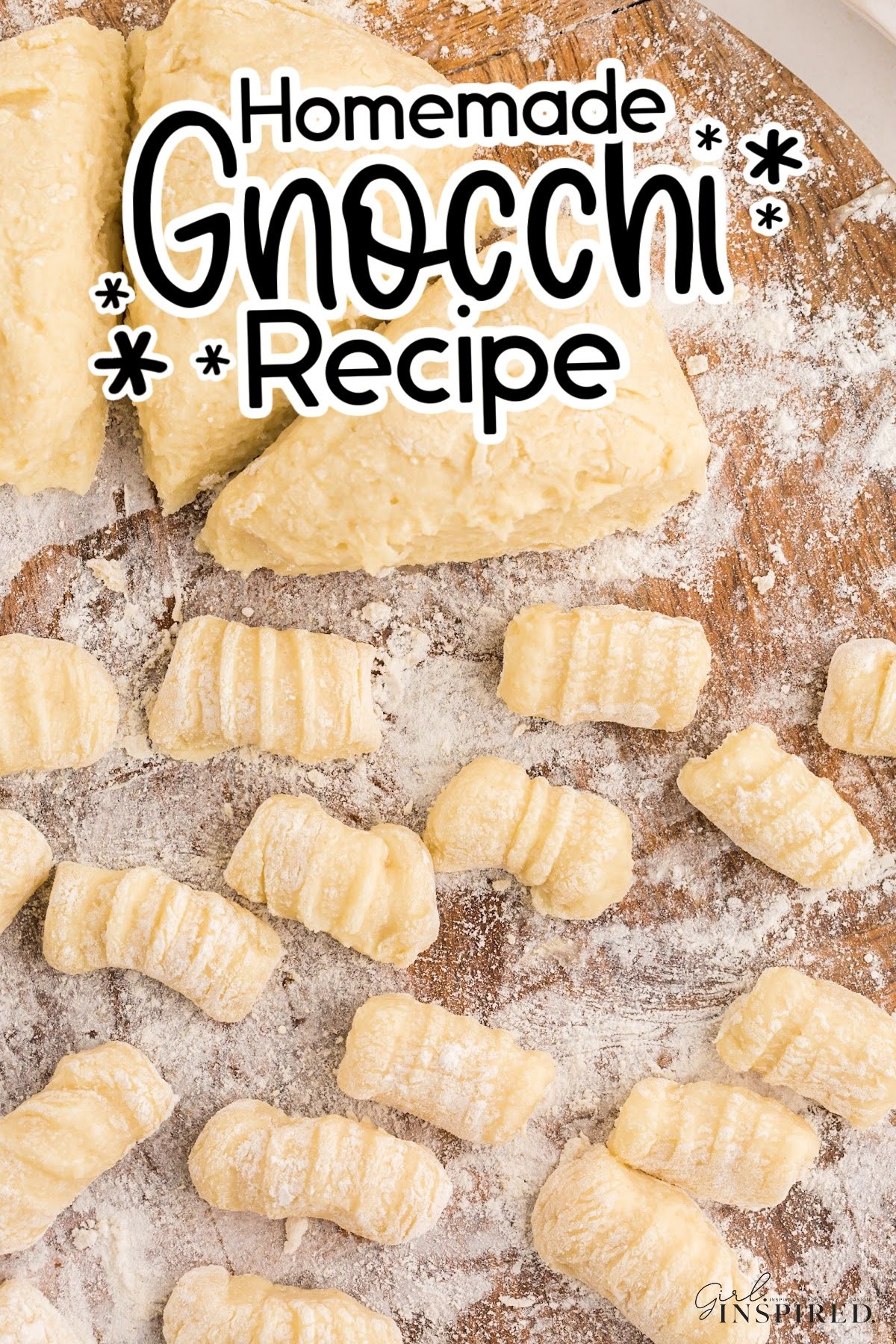 Homemade potato gnocchi on a wooden cutting board dusted with flour.