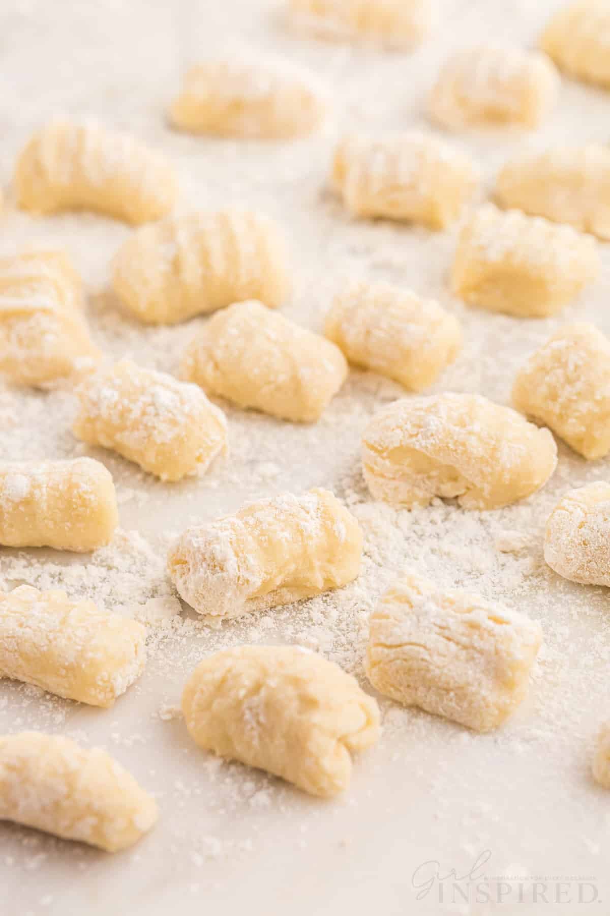 Homemade potato gnocchi on a sheet of parchment paper.