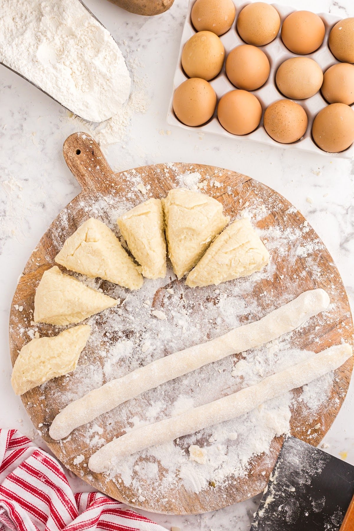 Rolling the dough pieces into long strips.