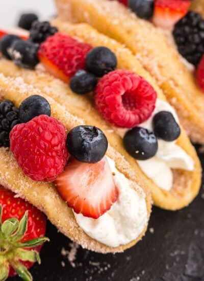 Dessert tacos filled with cheesecake filling and berries.