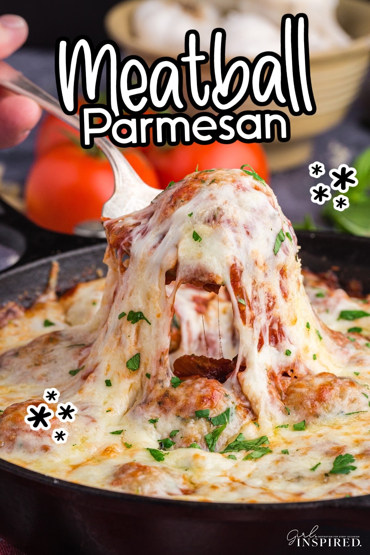 Meatball Parmesan in a skillet with one being removed and cheese dripping over the spoon, with text overlay.