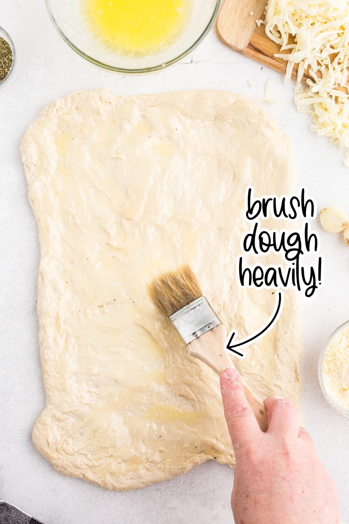 Brushing the dough with butter.