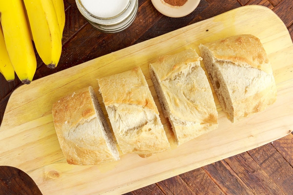 Thick sliced sour dough bread on a cutting board.