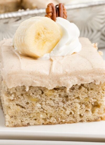 Slice of Banana Cake with cream cheese frosting, with text overlay.
