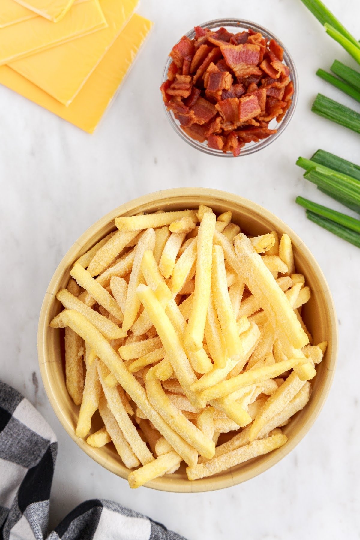 Frozen fries in a bowl to be seasoned.