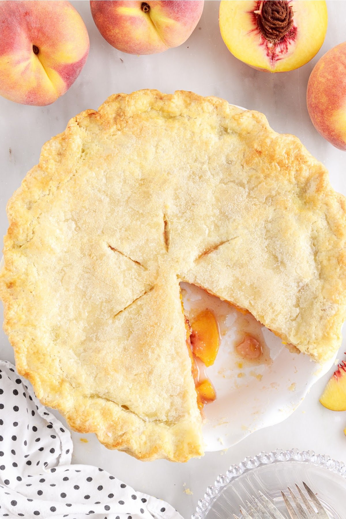 Baked peach pie with a slice removed.