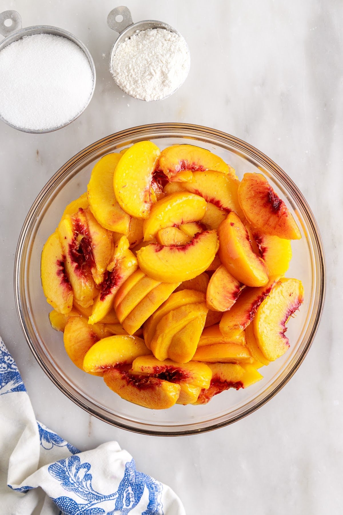 Large bowl filled with sliced peaches.