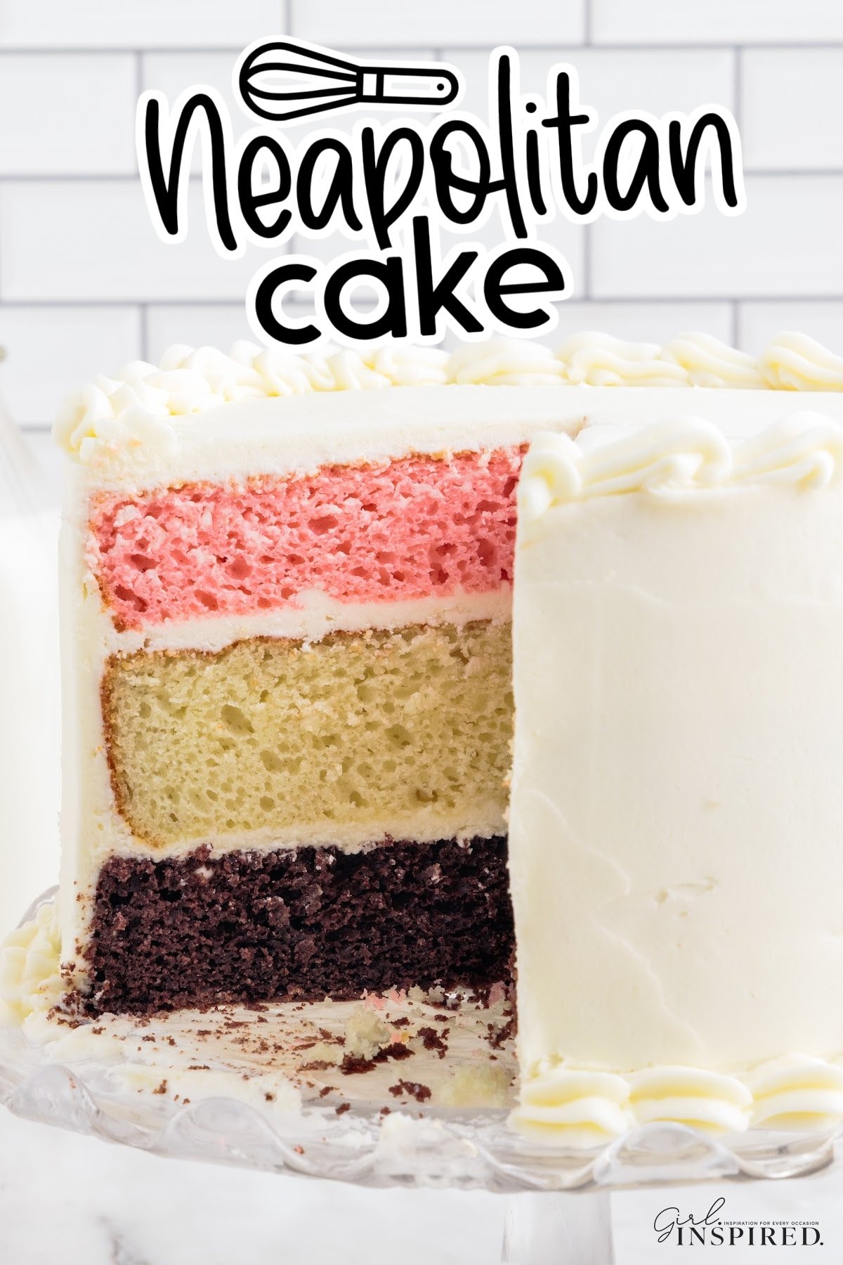 Neapolitan Cake frosted with white frosting, sliced open showing the layers.