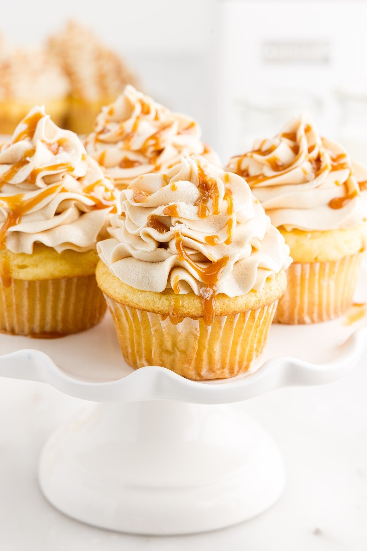 Drizzled caramel sauce on top of the frosted cupcakes.