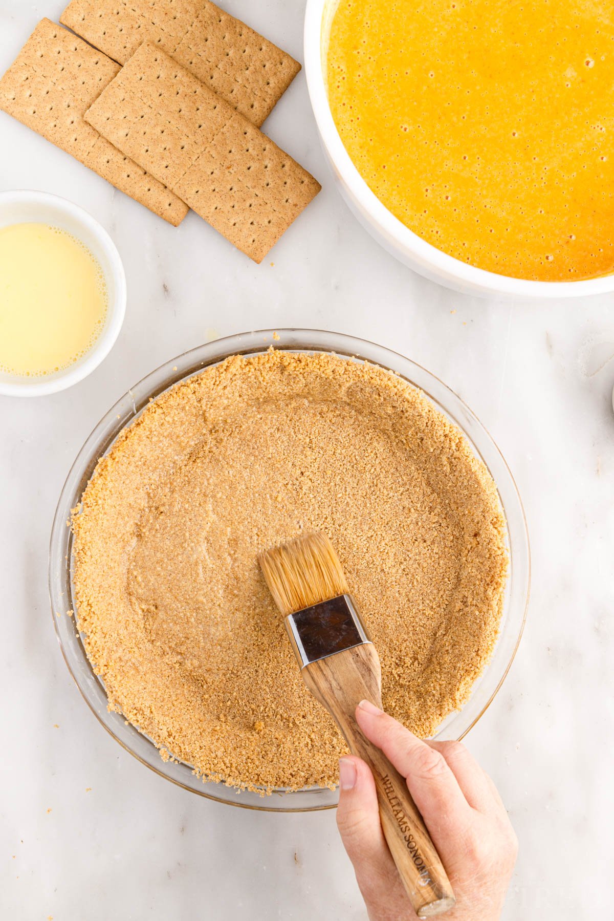 Brushing the graham cracker with a beaten egg.