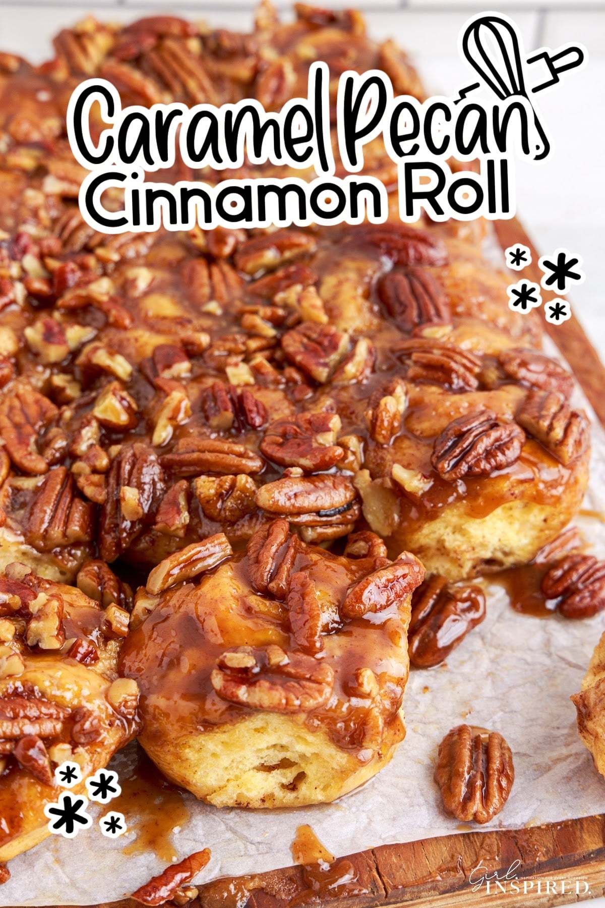 Caramel pecan cinnamon rolls on a piece of parchment paper.