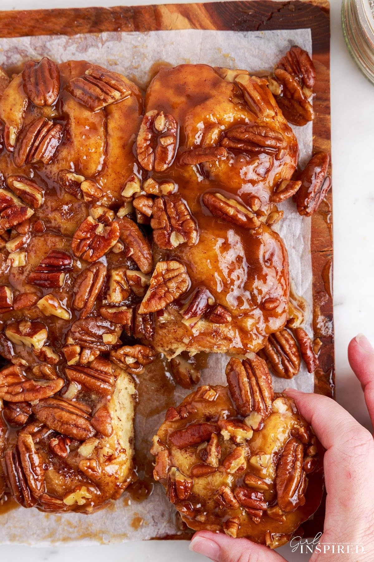 Pulling one of the Caramel pecan cinnamon rolls out from the rest.