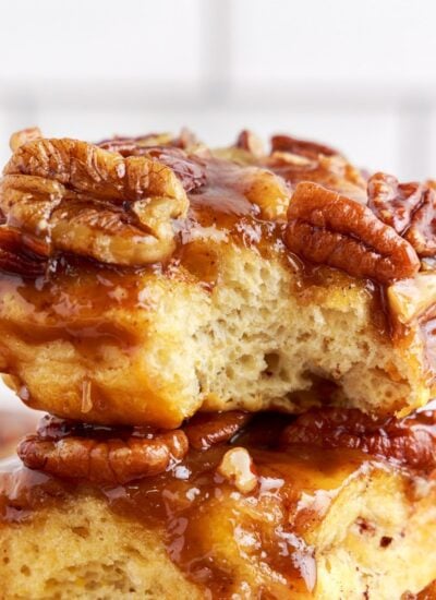 Close up of caramel pecan cinnamon rolls with a bite taken out.