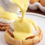 Topping eggs Benedict with hollandaise sauce that is homemade in the food processor.