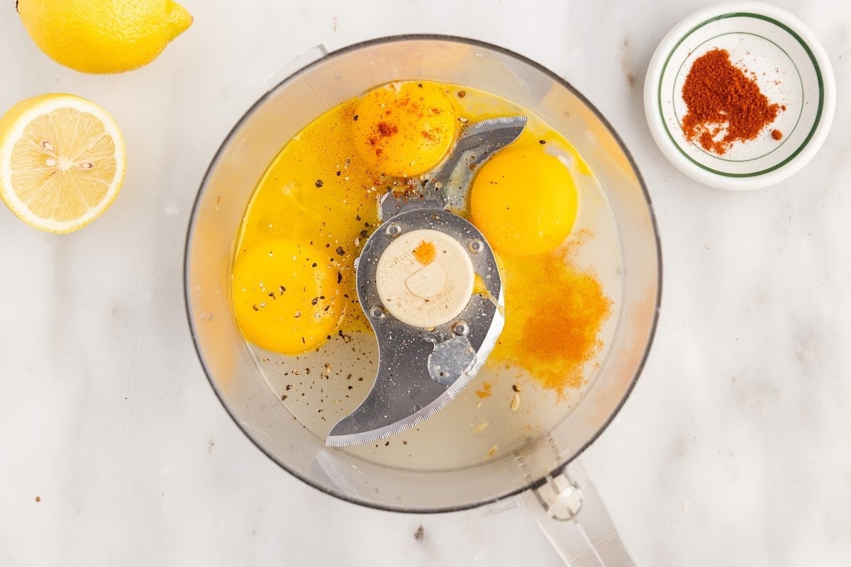 Egg yolks and spices in the food processor bowl.