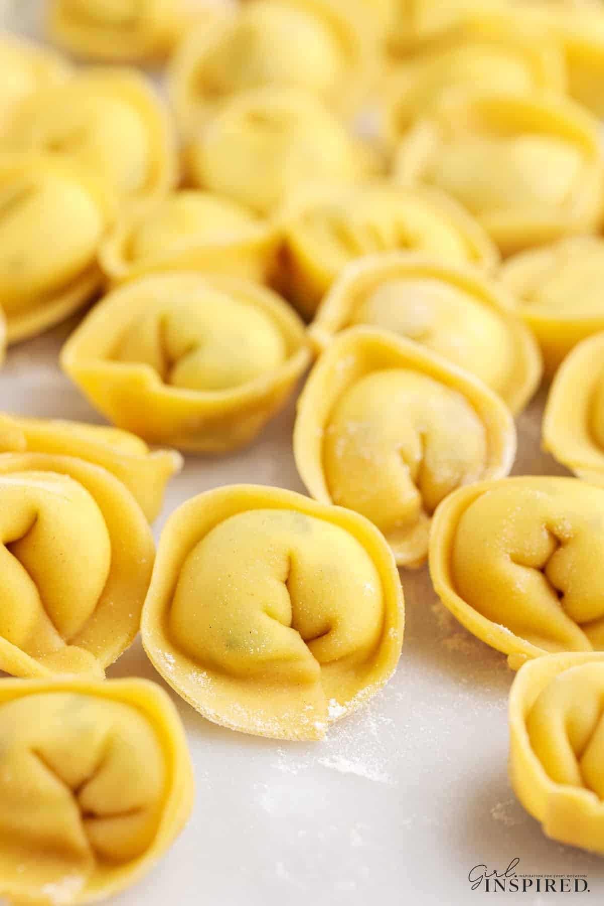 Homemade Tortellini laying on the counter, with text overlay.