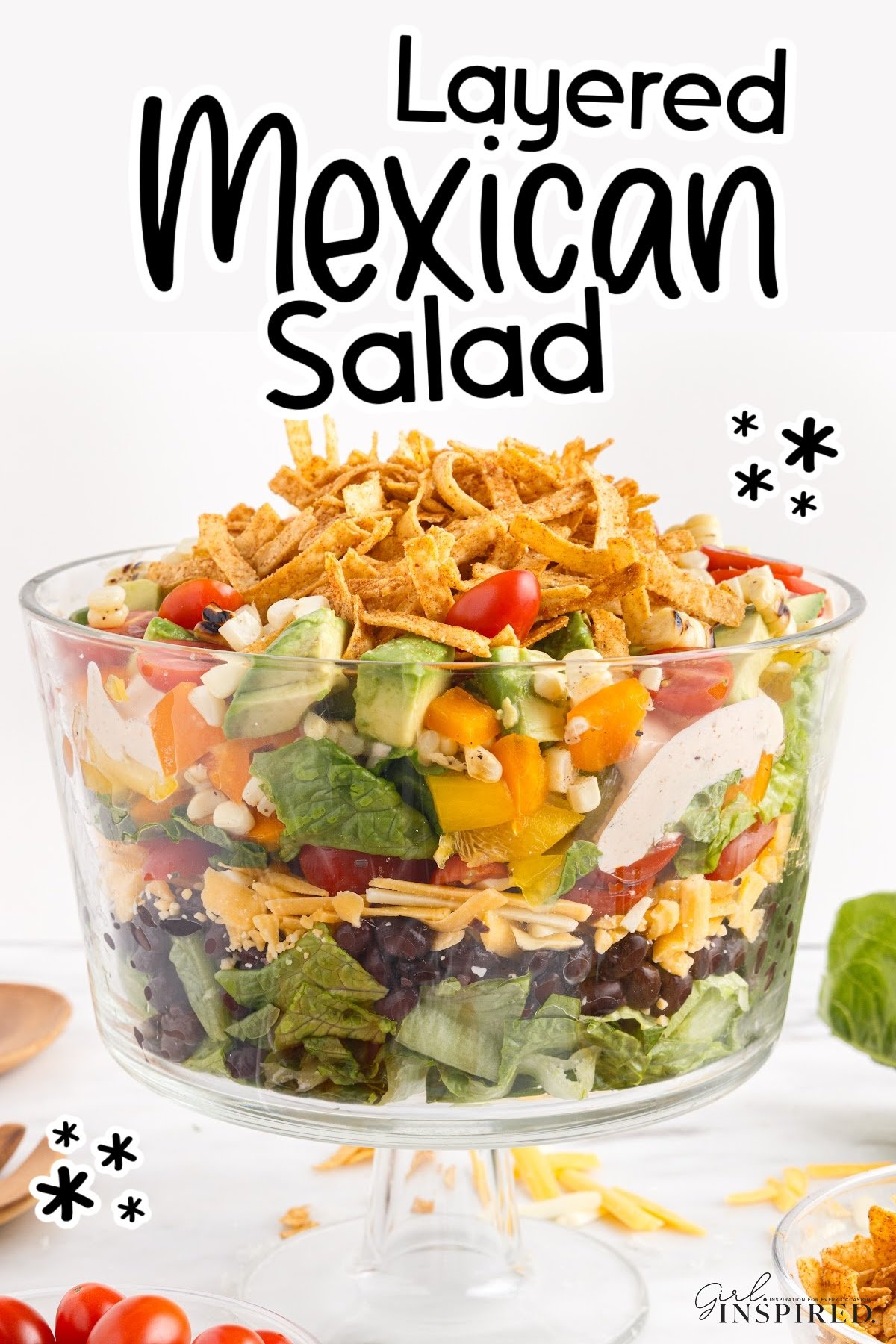 Layered Mexican salad in a large trifle dish.