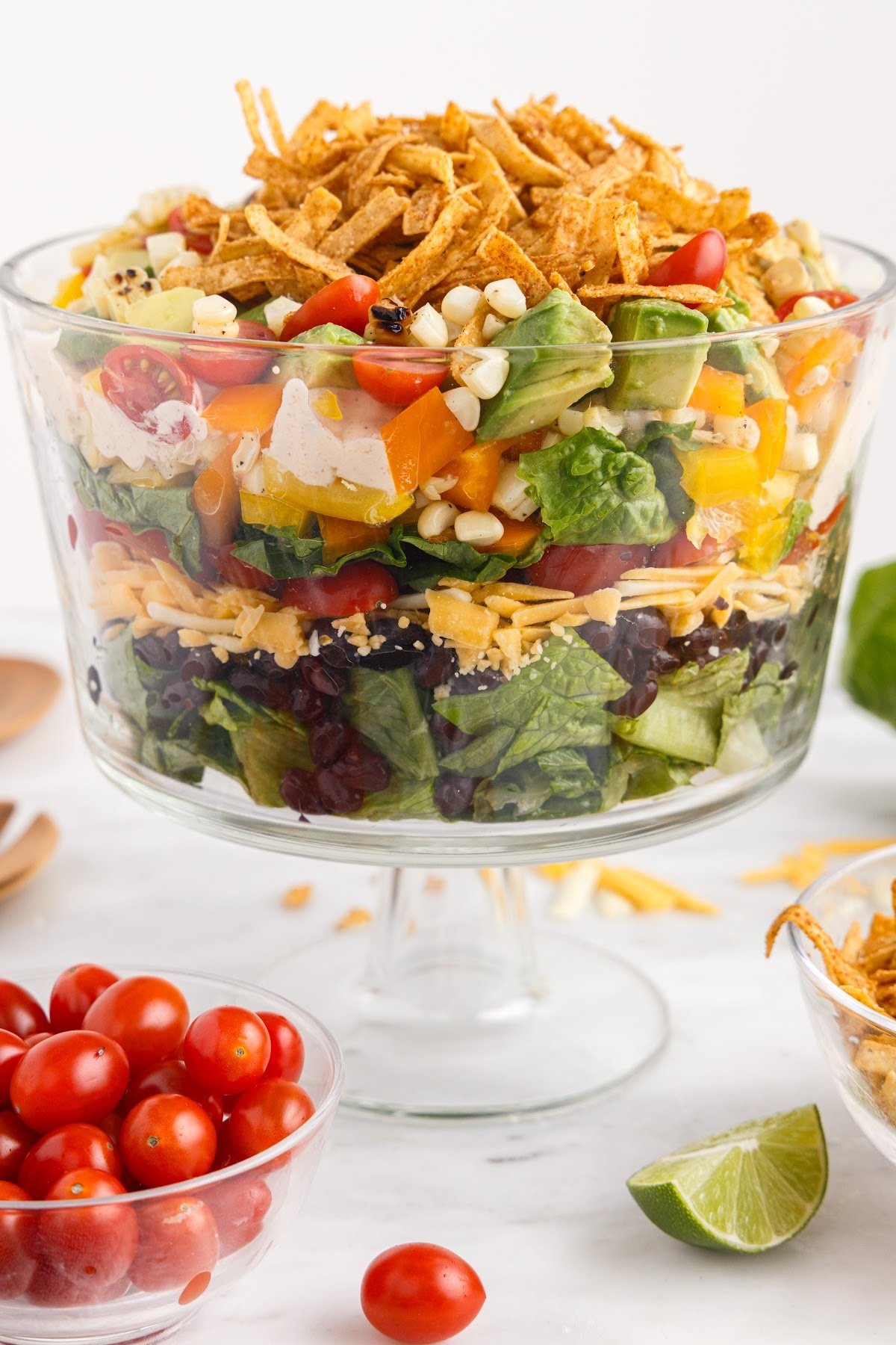 Layered Mexican salad next to tomatoes.