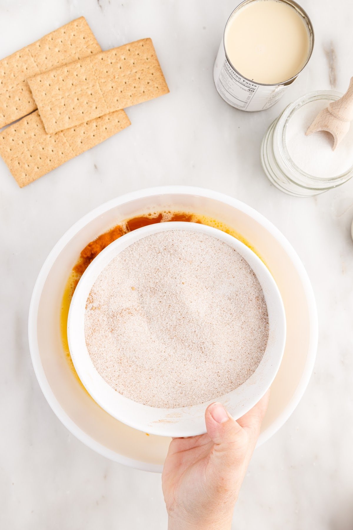 Adding the sugar mixture to the pumpkin puree.