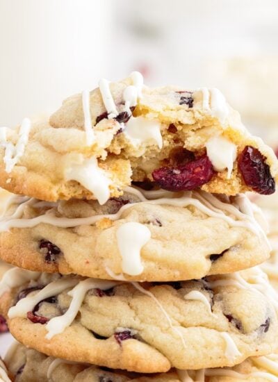 Vertical stack of cookies and one with a bite taken out of it.