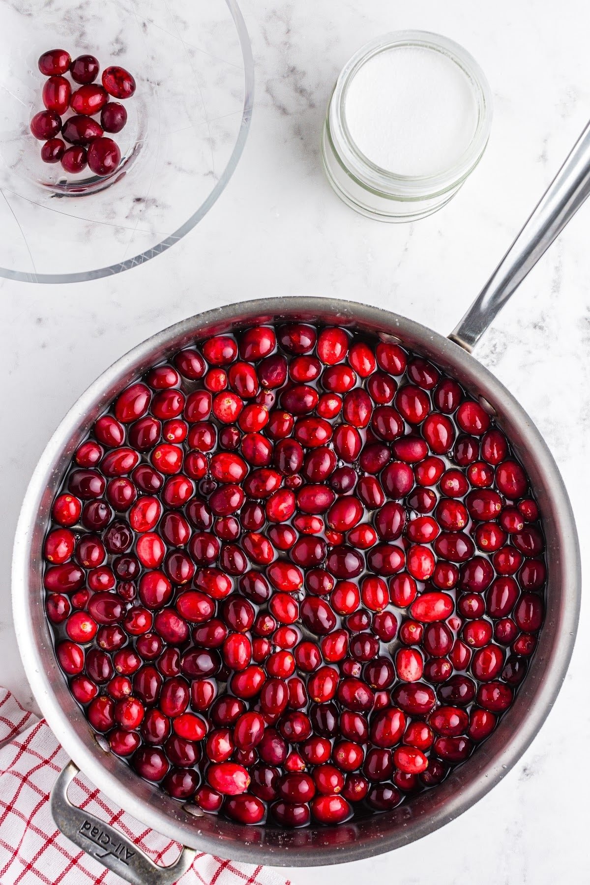 Adding cranberries to the simple syrup mixture.