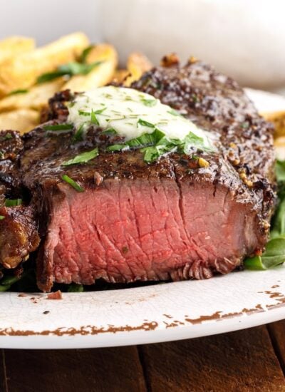 Piece of Air Fryer Filet Mignon on a plate, cut to see the inside, with text overlay.