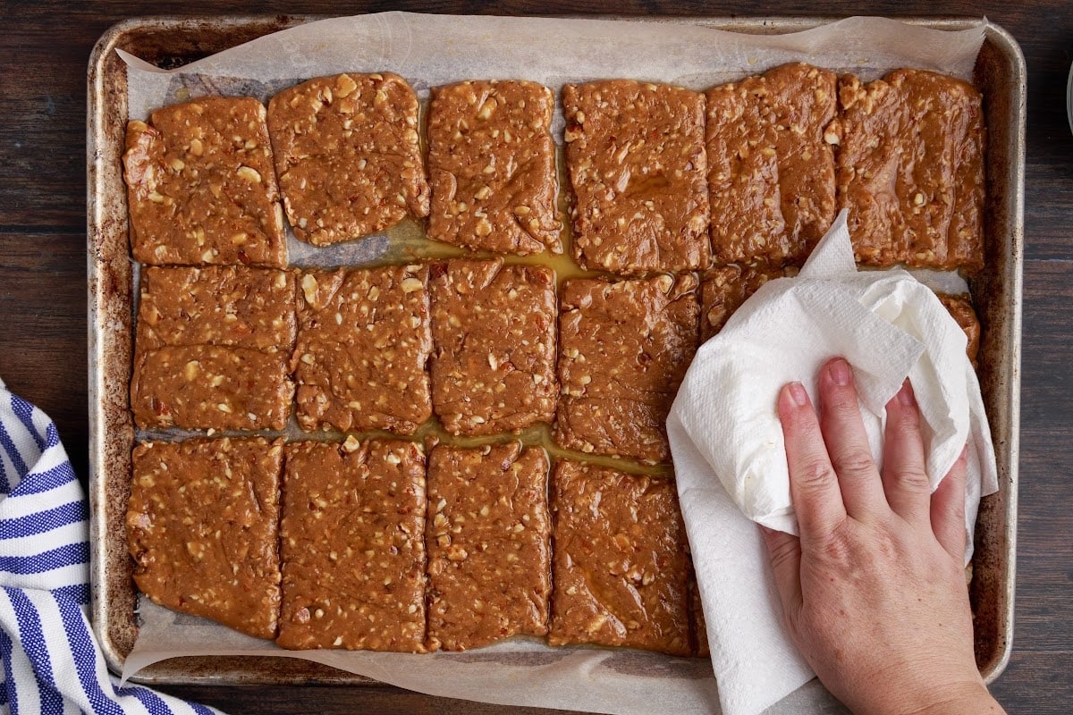 Blotting the frozen toffee with a paper towel.