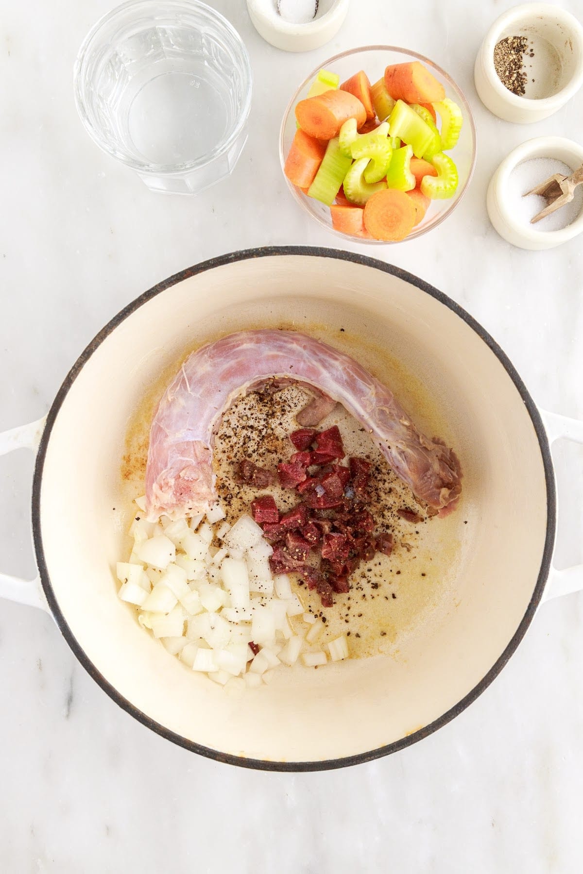 Spices and turkey neck in a pot on the stove.