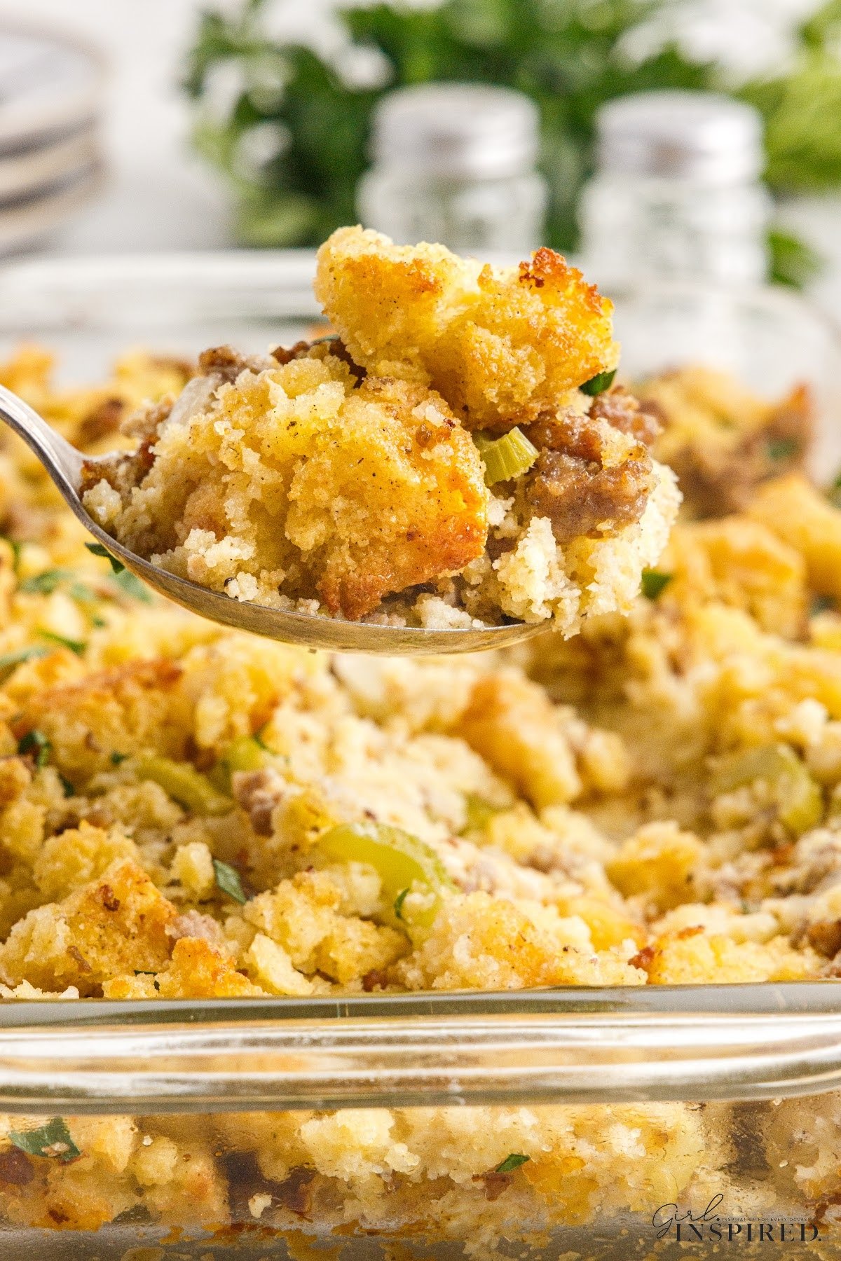 Close up of a spoon filled with Cornbread Sausage Stuffing.