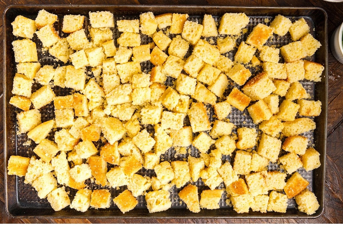 Laying the cornbread on the baking sheet to dry.