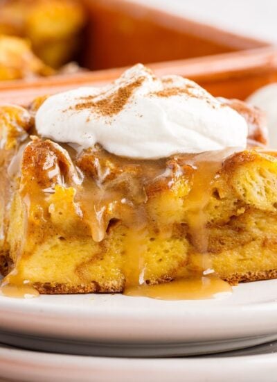 Slice of Pumpkin Bread Pudding on a plate with whipped cream on top