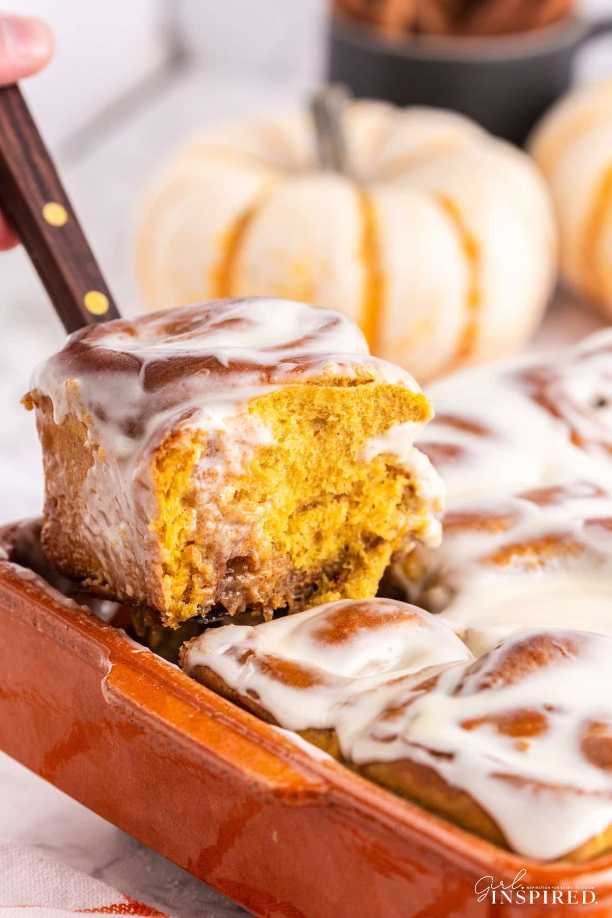 A slice of Pumpkin Spice Cinnamon Rolls on a plate, showing the inside.