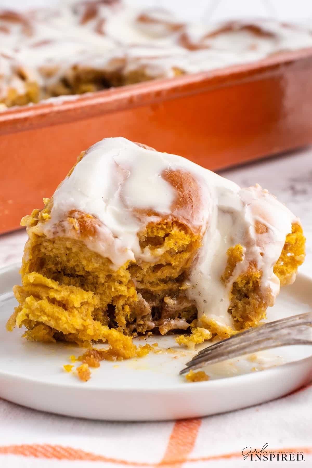 A slice of Pumpkin Spice Cinnamon Rolls on a plate, showing the inside.