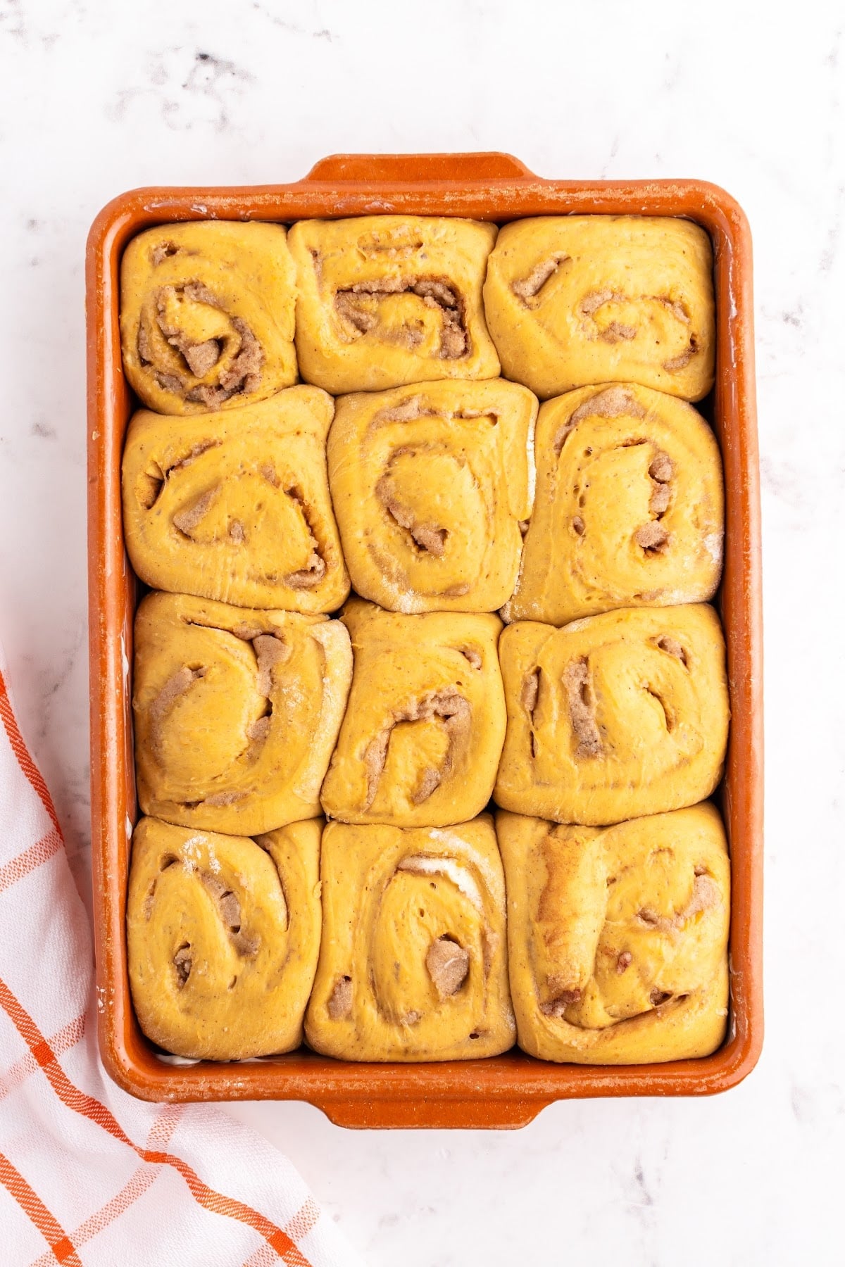 Buns in the baking dish that have set covered.