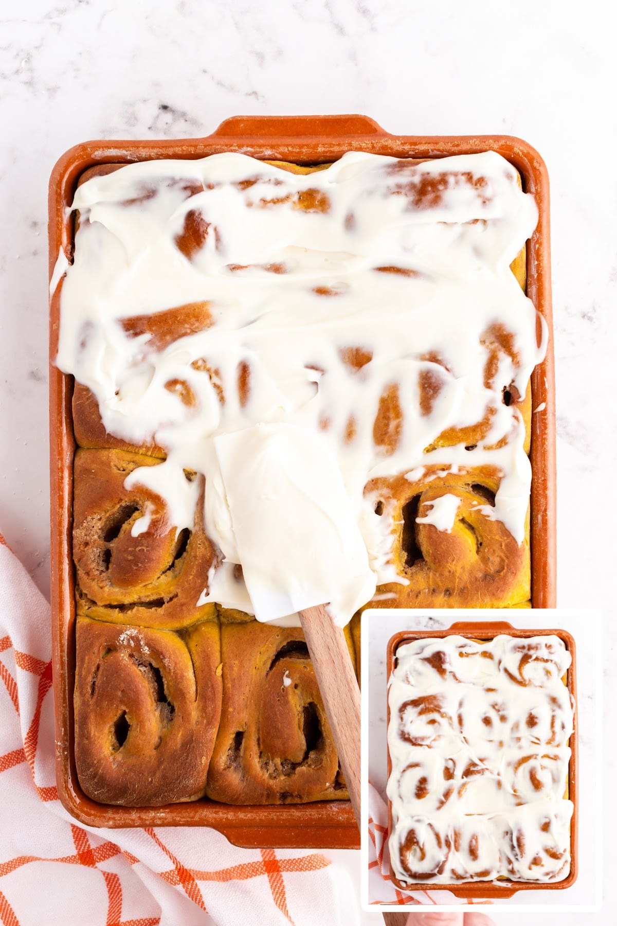 Spreading the icing over the top of the cooled cinnamon rolls.