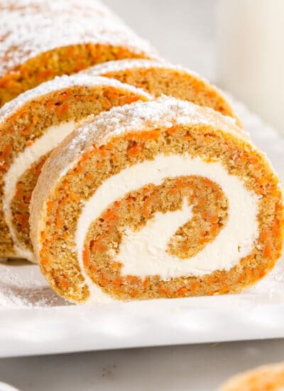 Slices of Carrot Cake Roll showing the inside roll and frosting on a platter,