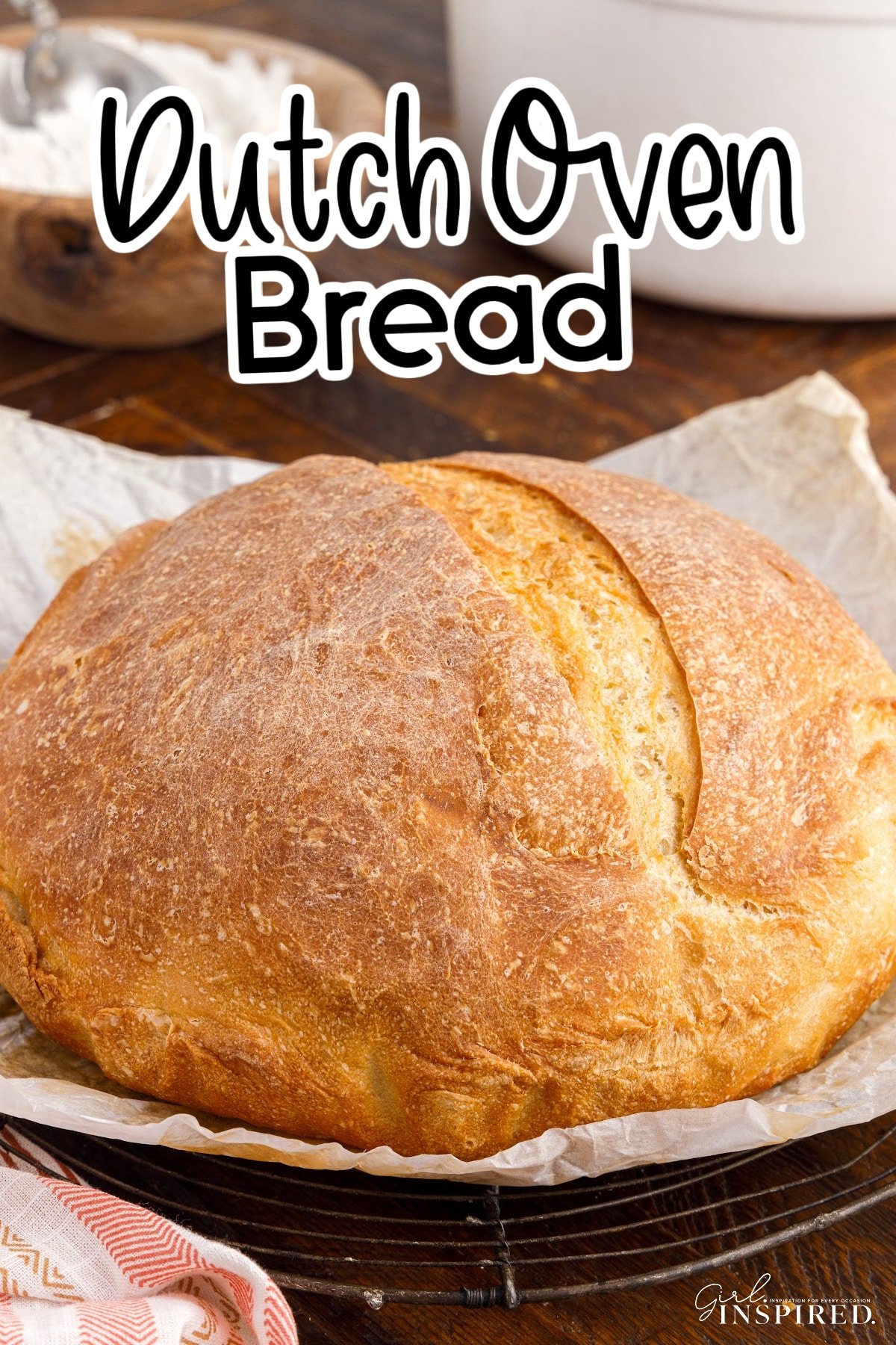 Loaf of Dutch Oven Bread on the wood cutting board, with ingredients in the background and text overlay.