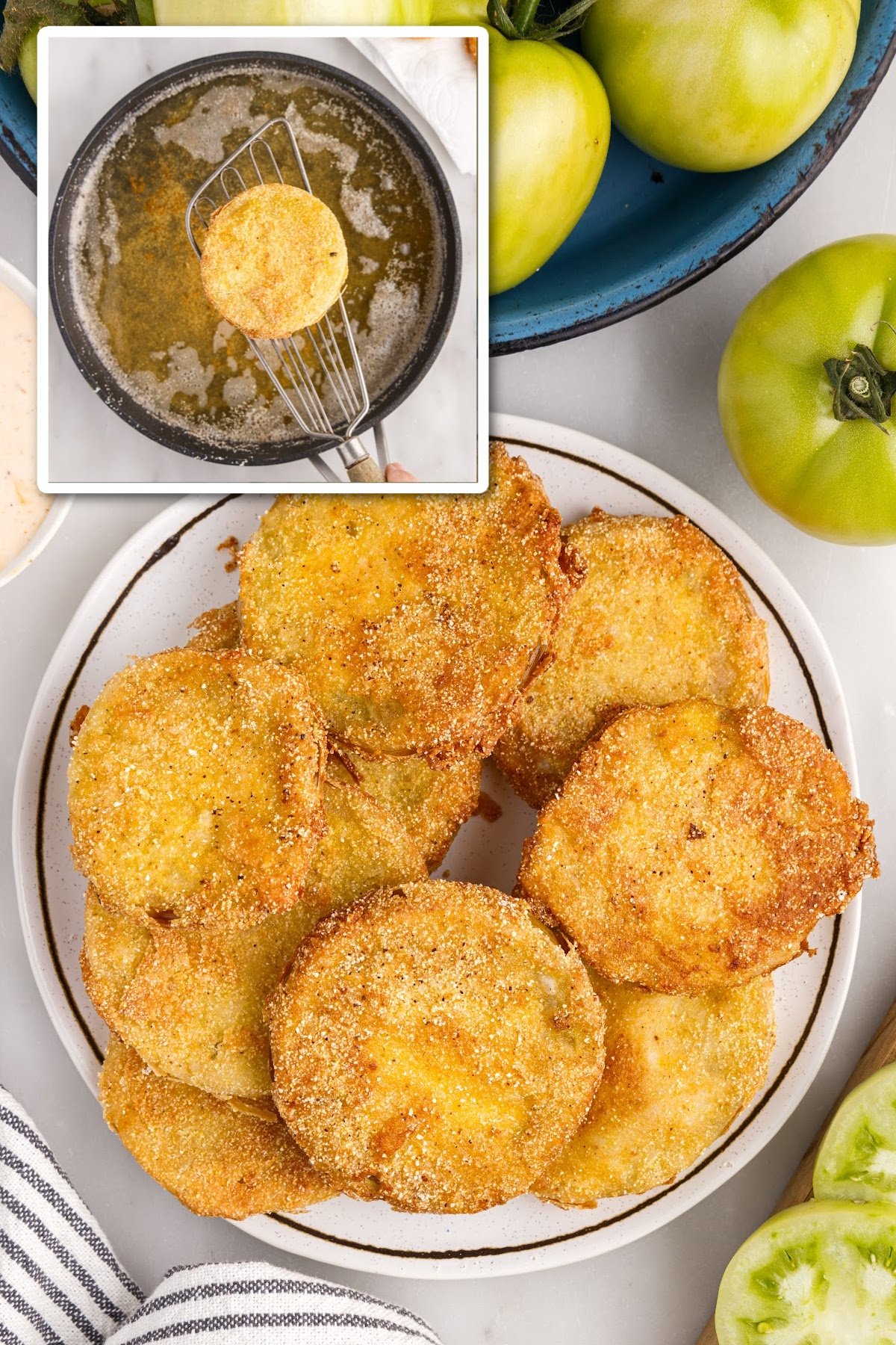 Finished fried green tomatoes on a platter, with a bowl of green tomatoes in the side.