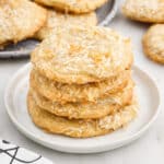 Stack of Chewy Coconut Cookies showing the flakes on the outside of the cookie, with text overlays.