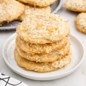 Stack of Chewy Coconut Cookies showing the flakes on the outside of the cookie, with text overlays.