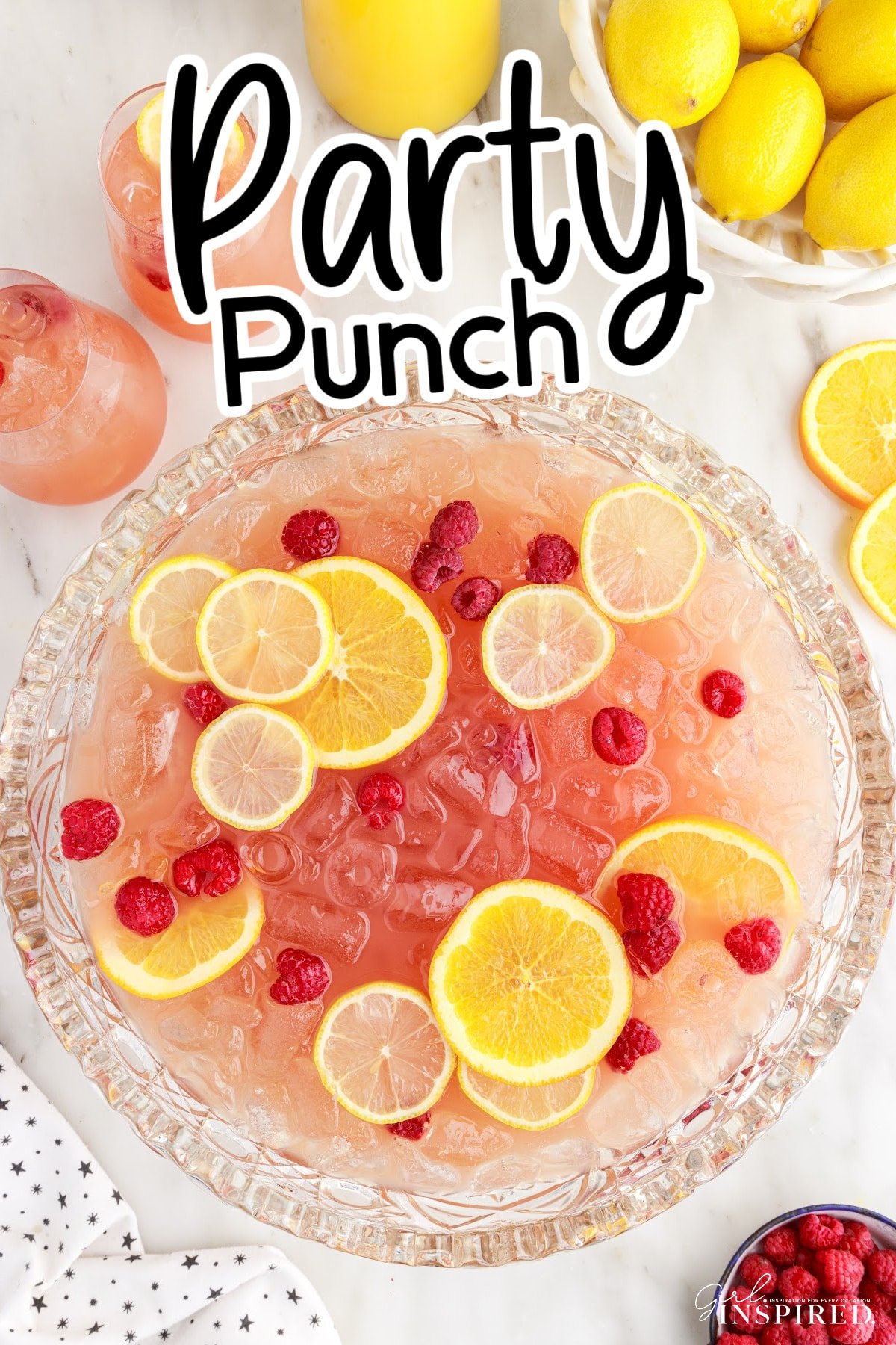 Top view of Party Punch Recipe showing the sliced lemons and berries inside the punch with other ingredients in the background.